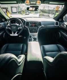 the interior of a car with black leather seats and steering wheel, dash lights on