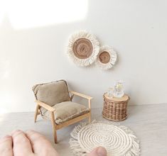 a person sitting in front of a chair next to a wall with two baskets on it