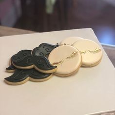 four decorated cookies sitting on top of a table