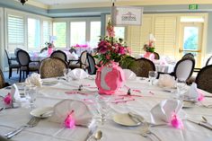 a table set up for a formal function with flowers and napkins on the table