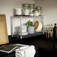 a shelf filled with dishes and jars on top of a wooden table