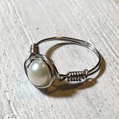 White pearls symbolize innocence, beauty, sincerity, and new beginnings. The White Pearl is a birthstone for June and symbolizes plenty of personality traits. People who have the pearl as their birthstone are said to be wise, pure, and wealthy. They’re also said to possess integrity, fidelity, and spirituality. This ring is made with a White Pearl wrapped in Stainless Steel Wire. Palm Jewelry, White Pearl Ring, Ring Wire, White Opal Ring, Be Wise, Diy Wire Jewelry, Handcrafted Rings, Stainless Steel Wire, Personality Traits