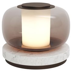 a white and brown table lamp on top of a marble base with a glass dome