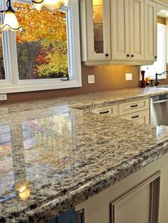 a large kitchen with granite counter tops and white cabinets