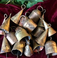 a bunch of bells sitting on top of a red cloth