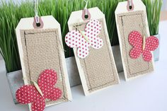 three wooden tags with red and white polka dots on them are hanging from a planter