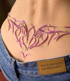 the back of a woman's stomach with pink string attached to her chest and an adhesivement sticker on it