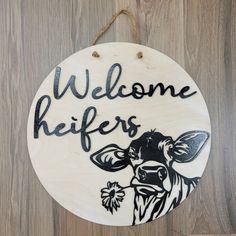 a wooden sign that says welcome heres with a cow and flowers painted on it