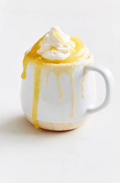 a cup filled with whipped cream and yellow liquid