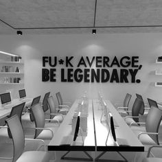 an empty conference room with chairs and desks in front of a large sign that reads fu - k average, be legendary