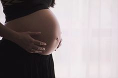 a pregnant woman's belly is shown with her hands on her stomach and the other side of her body