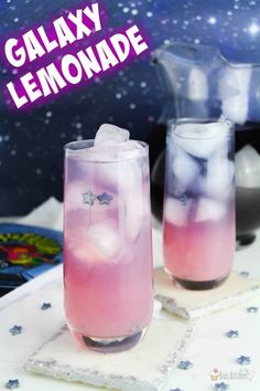 two glasses filled with liquid sitting on top of a white table next to each other