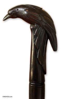 a bronze statue of a bird on top of a wooden pole with a white background