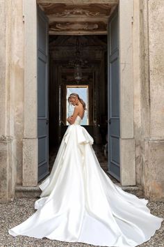 a woman in a white wedding dress is posing for the camera