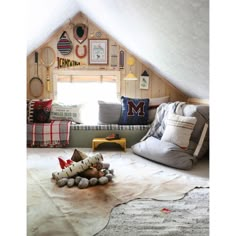 an attic bedroom with lots of pillows and decor on the walls, along with stuffed animals