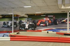 an indoor race track with cars on it