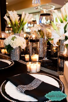 the table is set with candles, flowers and napkins for an elegant dinner party