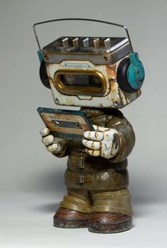 an old fashioned robot with headphones on holding a cell phone