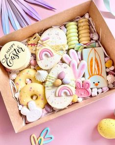 a box filled with lots of decorated cookies and candies on top of a table