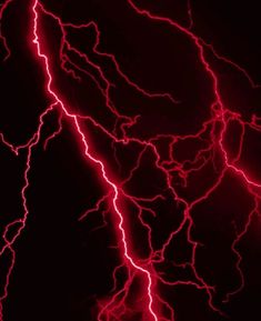 red lightning strikes in the dark sky with bright lights on its face and back ground