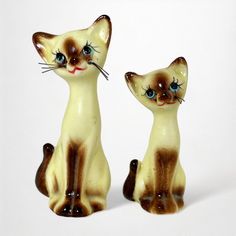 two ceramic cats sitting next to each other