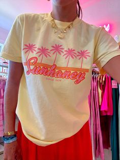 Our EXCLUSIVE Sunhoney Retro Palm Tee in Yellow screams summer vibes with its playful graphic of pink palm trees and orange retro design. Featuring our classic logo in a stunning orange and pink colorway, this tee is the perfect addition to your warm weather wardrobe. This summer graphic is printed on Comfort Colors tee and is a full length, shirt is tucked in for photos for styling purposes. Get yours now and be prepared to wear all summer long! Product is made to order: available for pick up/s Cheap Peach T-shirt With Graphic Print, Tropical T Shirt Designs, Affordable Multicolor Retro Print T-shirt, Print On Demand Clothing, Tshirt Product Photo, Yellow T-shirt For Spring Vacation, Retro Printed Summer T-shirt, Retro Summer T-shirt With Front Print, Vintage Printed T-shirt For Summer