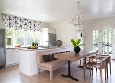 a kitchen and dining room with white walls, hardwood floors and an open floor plan