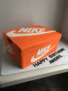 a birthday cake with an orange nike box on it