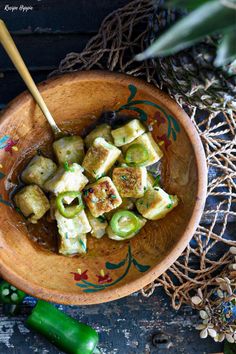 a wooden bowl filled with food on top of a table