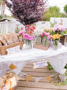 a table topped with lots of vases filled with flowers