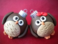 two chocolate owls with bows and tinsel on their heads are sitting side by side