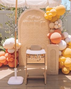 a chair under an umbrella in front of some balloons