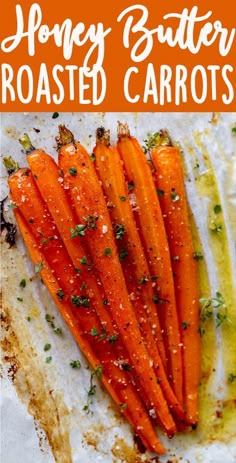 carrots with herbs and seasoning sitting on top of a piece of parchment paper