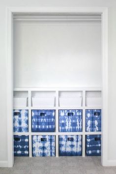 a white closet filled with blue boxes and baskets