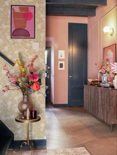 the hallway is decorated in pink, blue and gold with floral arrangements on either side