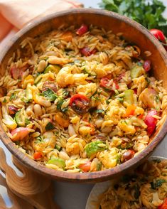 a wooden bowl filled with rice and vegetables