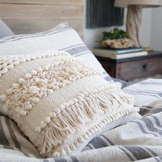 a close up of a pillow on a bed with a wooden headboard in the background