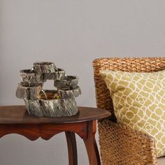 a wooden table topped with two vases next to a brown chair and yellow pillow