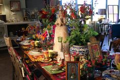 a dining room filled with lots of clutter and flowers on top of the table