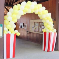 an arch made out of popcorn buckets with balloons attached to the top and bottom