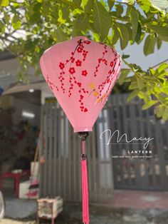 a pink paper lantern hanging from a tree