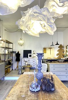 a room filled with lots of different types of furniture and lighting hanging from the ceiling