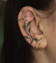 a close up of a person's ear with tattoos on it