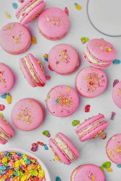 pink macaroons with sprinkles next to a bowl of colorful cereal