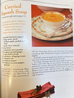 the recipe book is open to show an image of soup in a cup and saucer