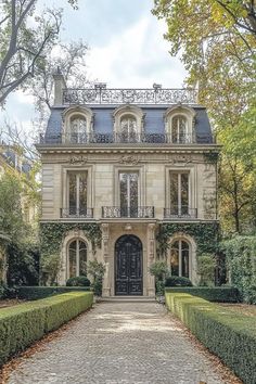 a large house with hedges and trees around it