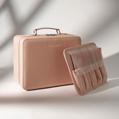 a piece of luggage sitting on top of a white floor next to a pink case