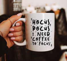 a person holding a coffee mug with the words hoccus pocus i need coffee to focus