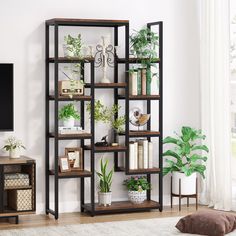 a bookshelf with plants and pictures on it in the corner of a room