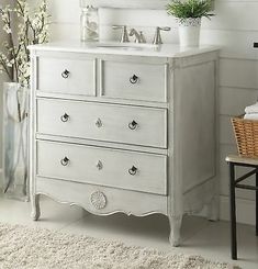 a white dresser sitting in front of a mirror